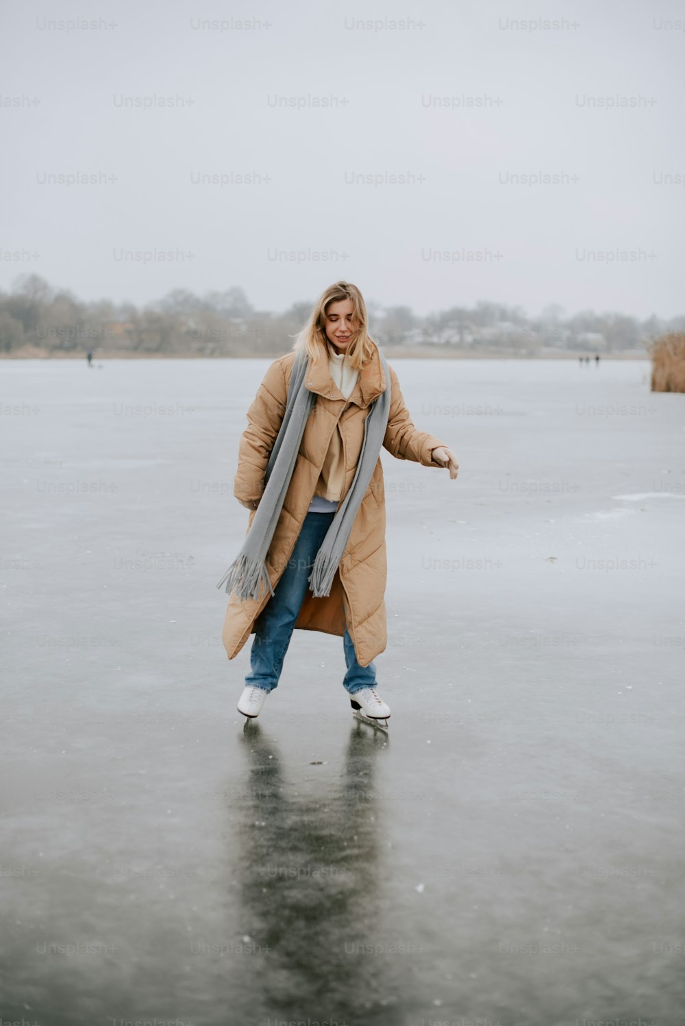 a woman is standing on a frozen lake