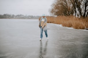 Un homme marchant sur un lac gelé tenant une planche à roulettes