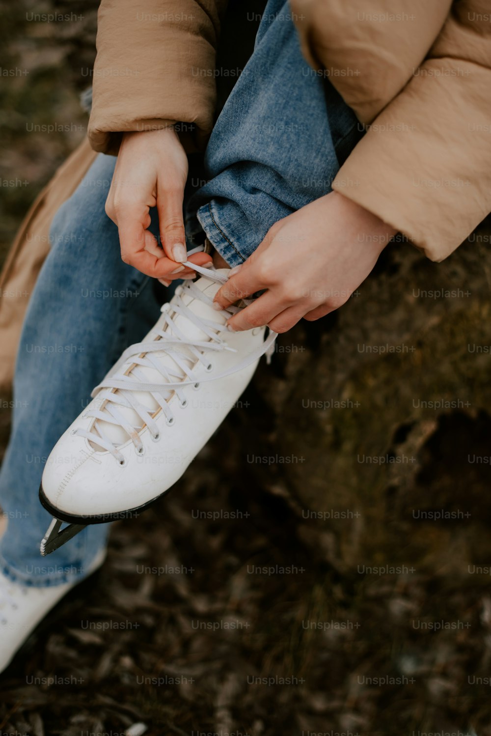 une personne attachant une paire de chaussures blanches