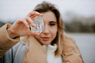 a woman holding a piece of ice in her hand