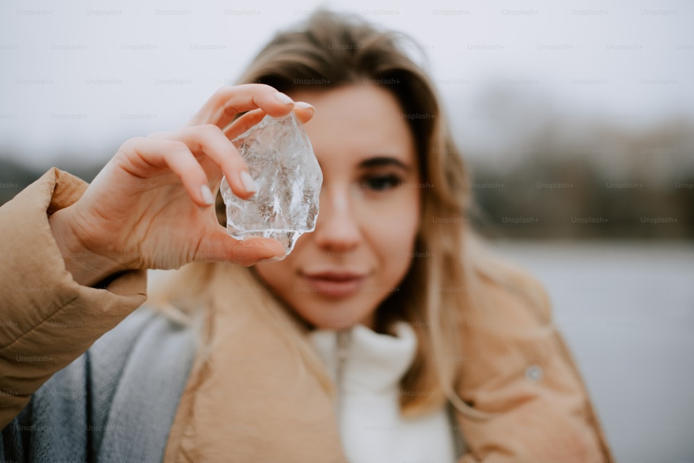 a woman holding a piece of ice in her hand