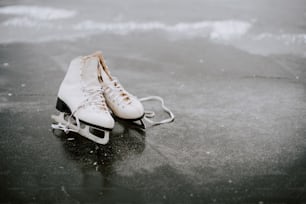 um par de patins de gelo sentados em uma superfície molhada