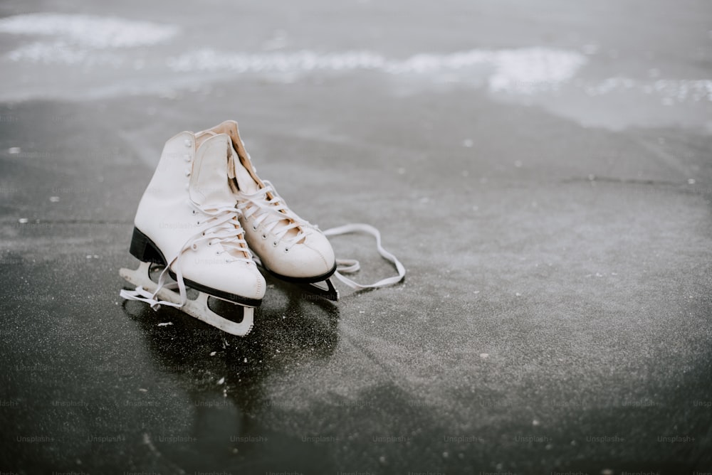 Un par de patines de hielo sentados sobre una superficie mojada
