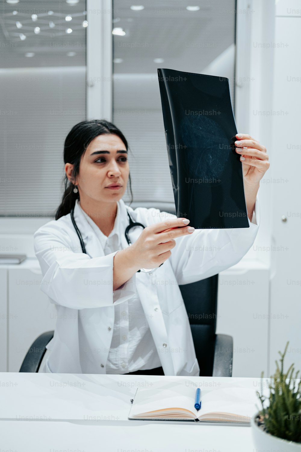 Eine Frau im weißen Laborkittel hält ein Buch in der Hand