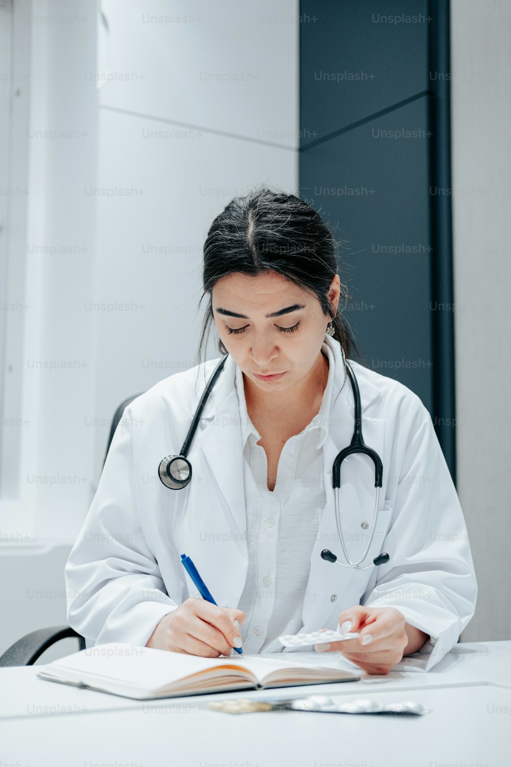 a woman in a white lab coat writing on a book
