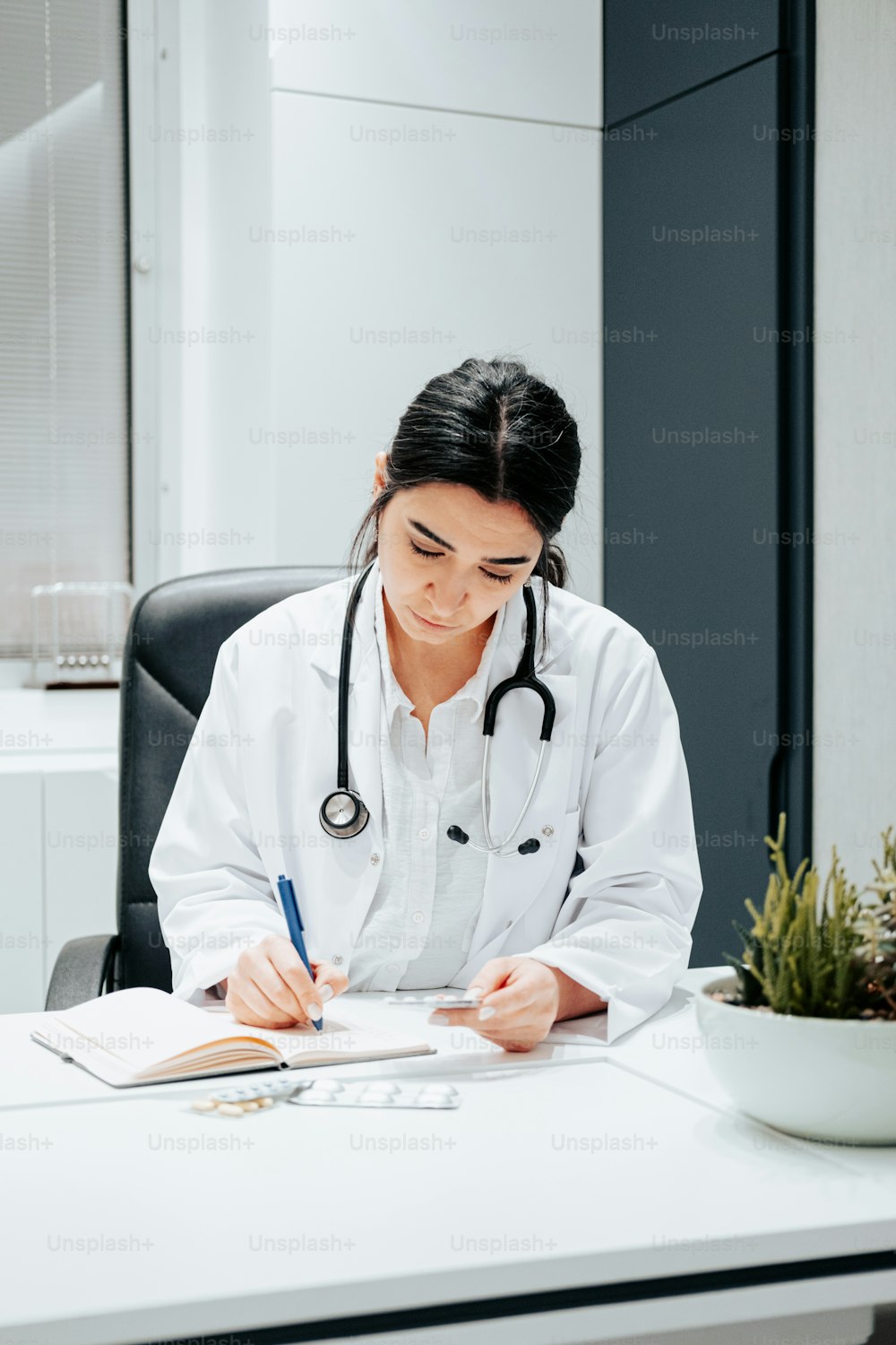 a woman in a white lab coat writing on a notepad