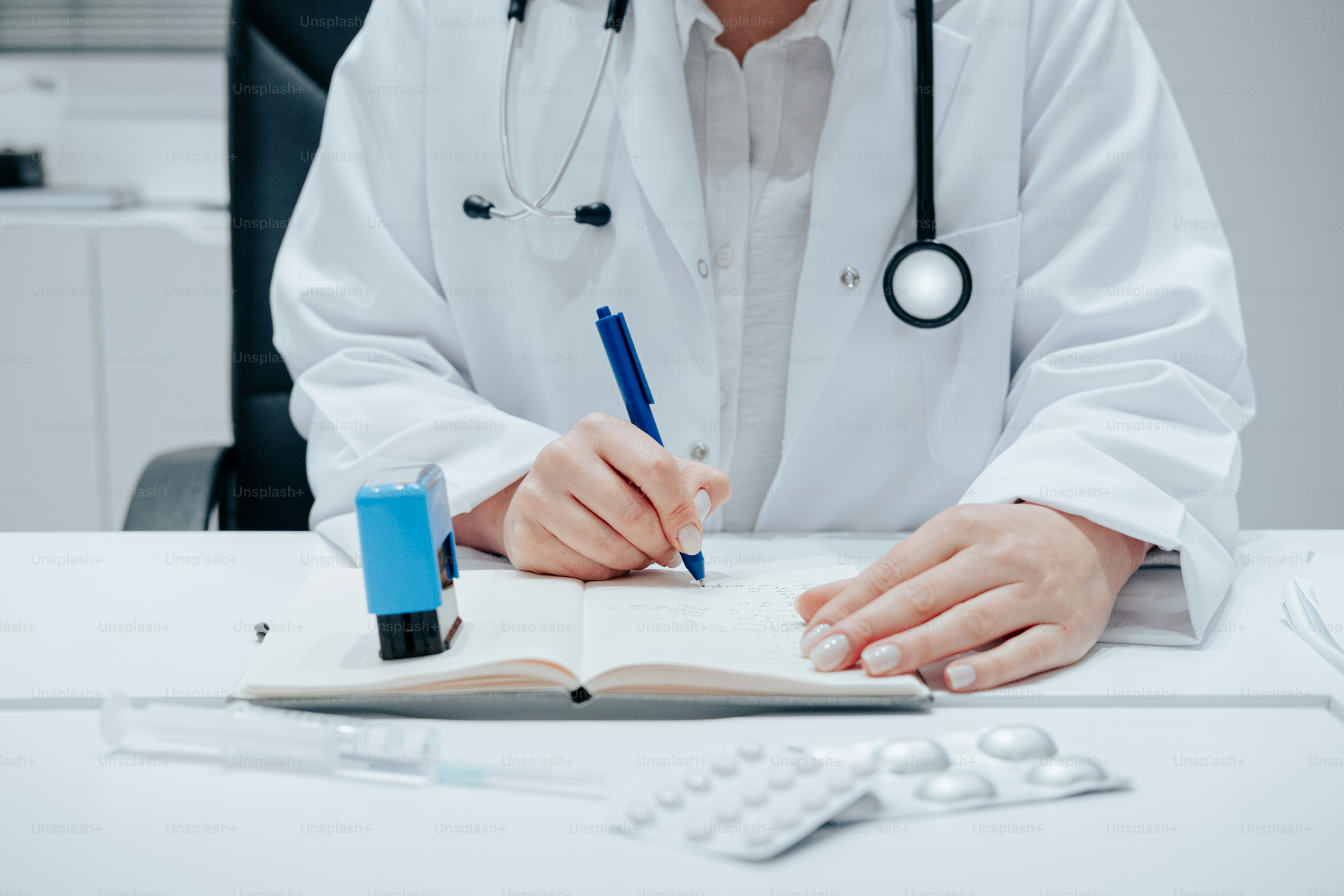 a person in a white coat writing on a book
