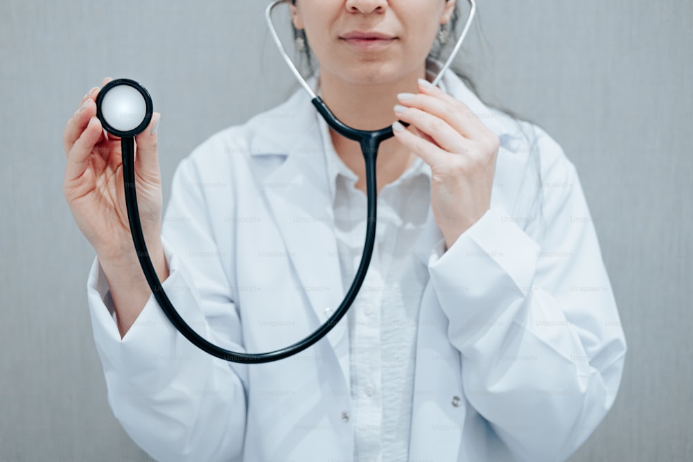 Una donna in camice bianco che tiene uno stetoscopio