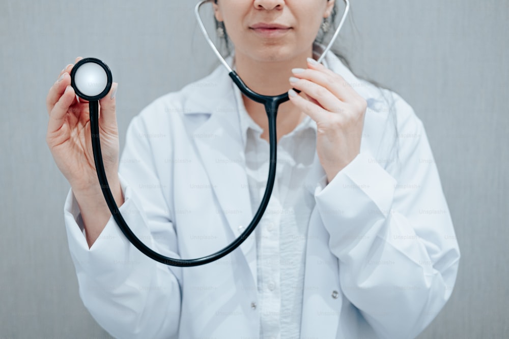 a woman in a white lab coat holding a stethoscope