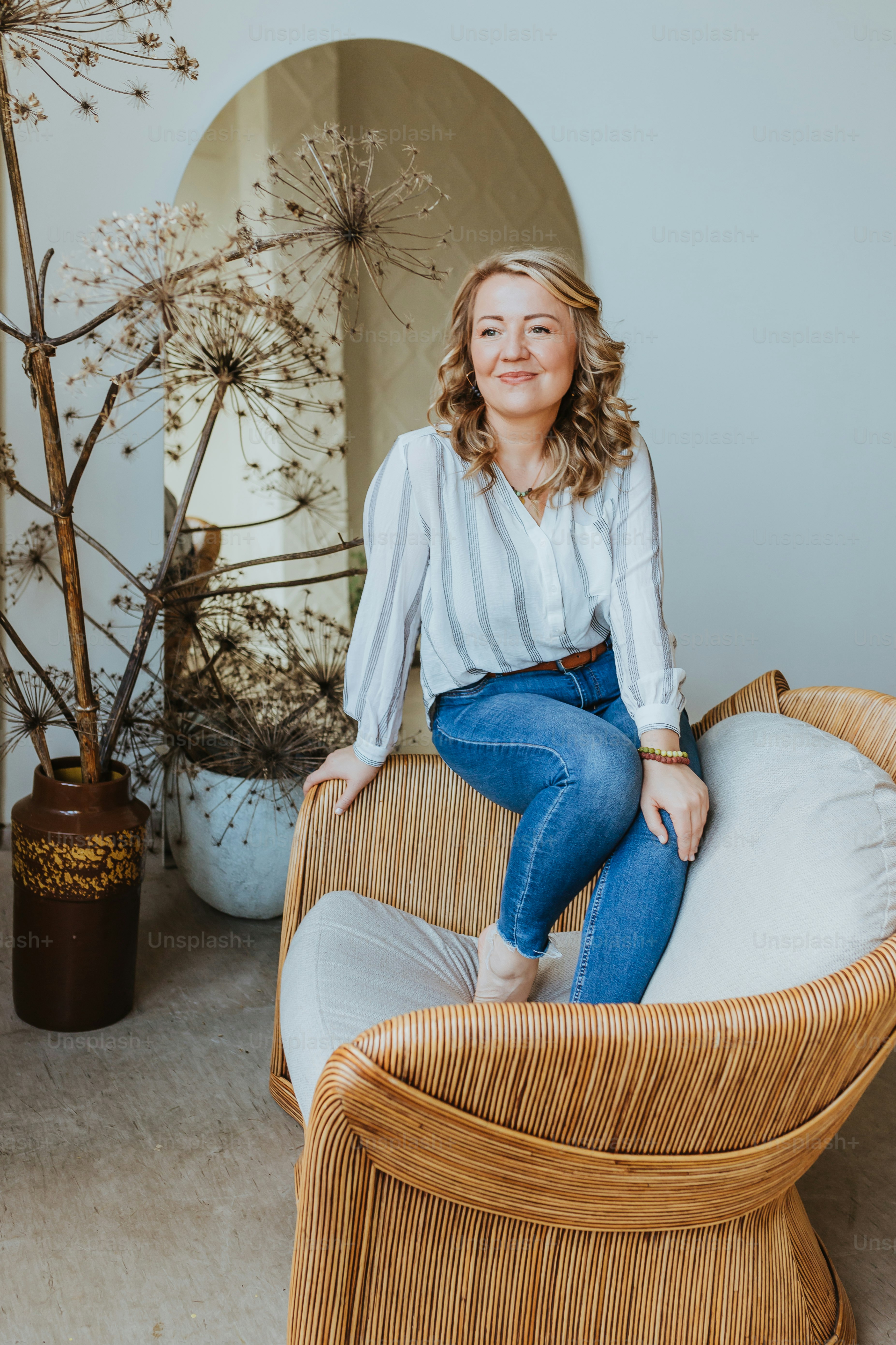 a woman sitting on top of a wicker chair