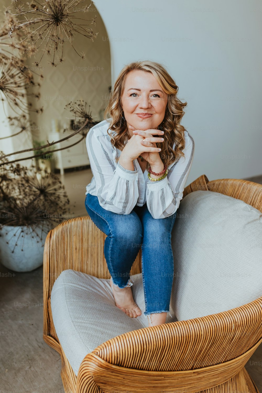 a woman sitting on top of a wicker chair