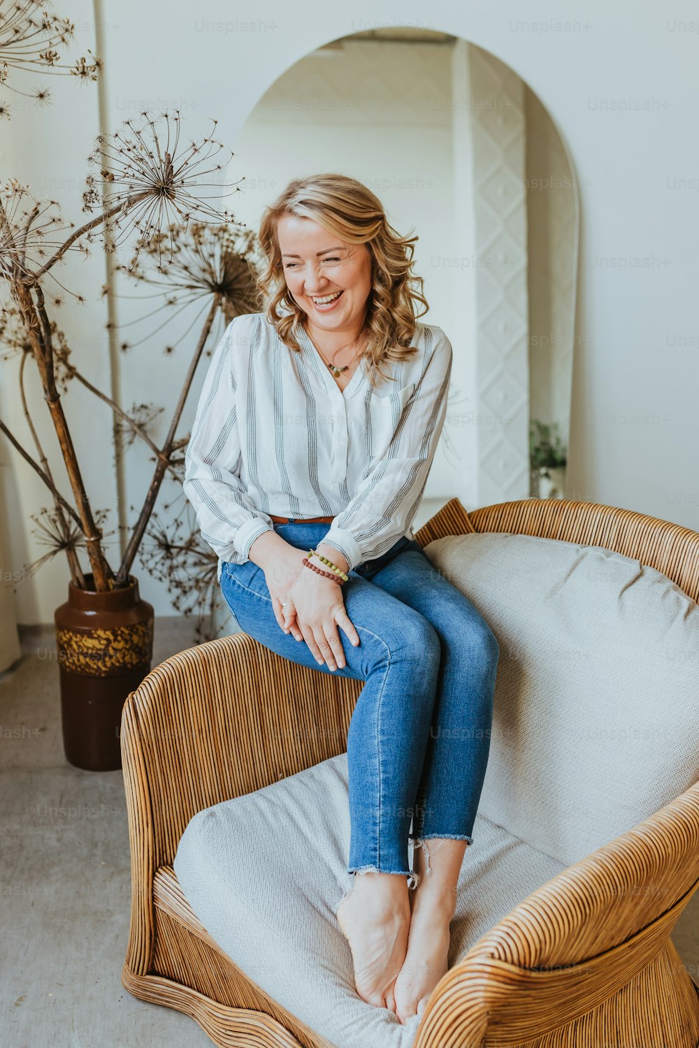 a woman sitting on top of a wicker chair