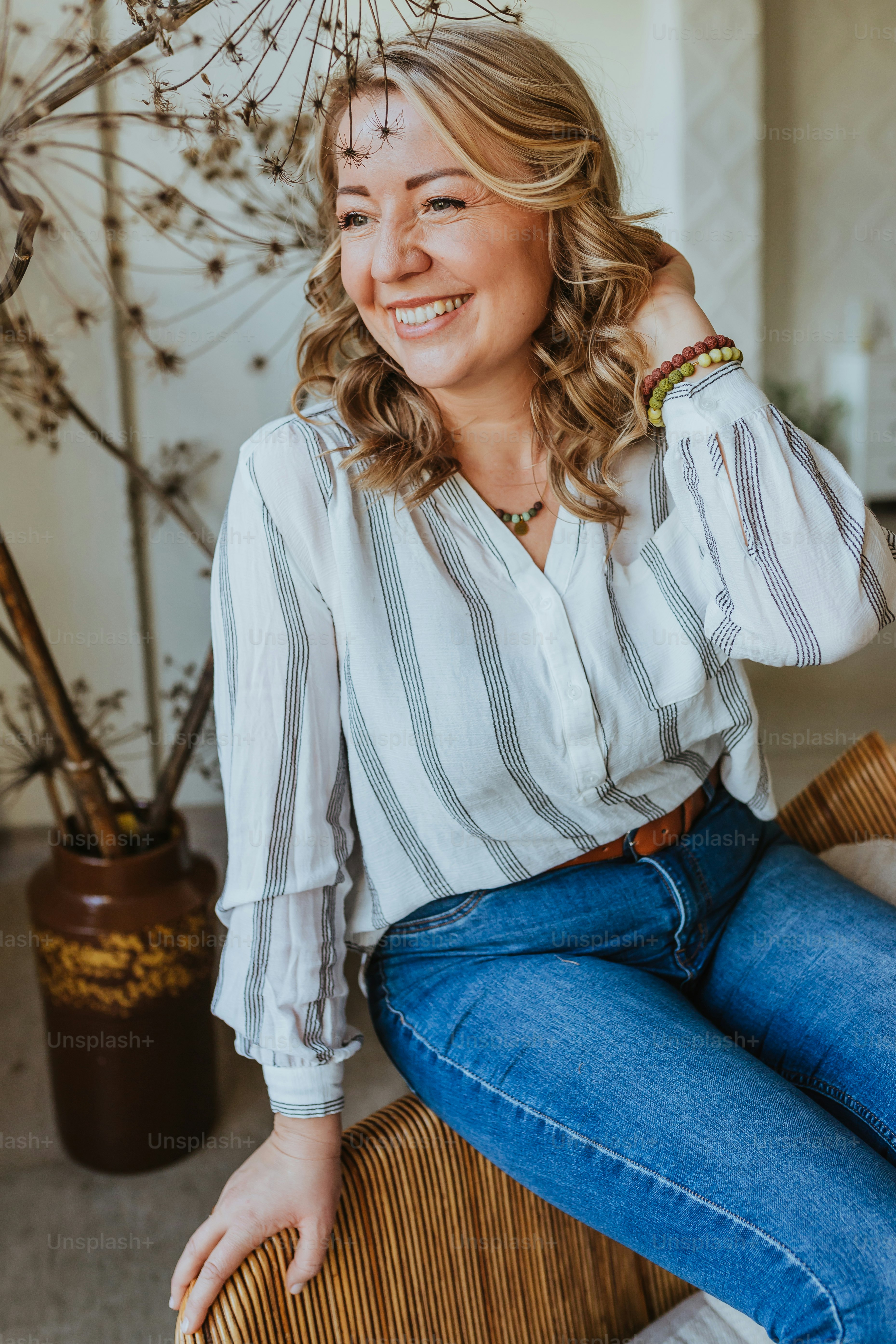 a woman sitting on a wicker chair smiling