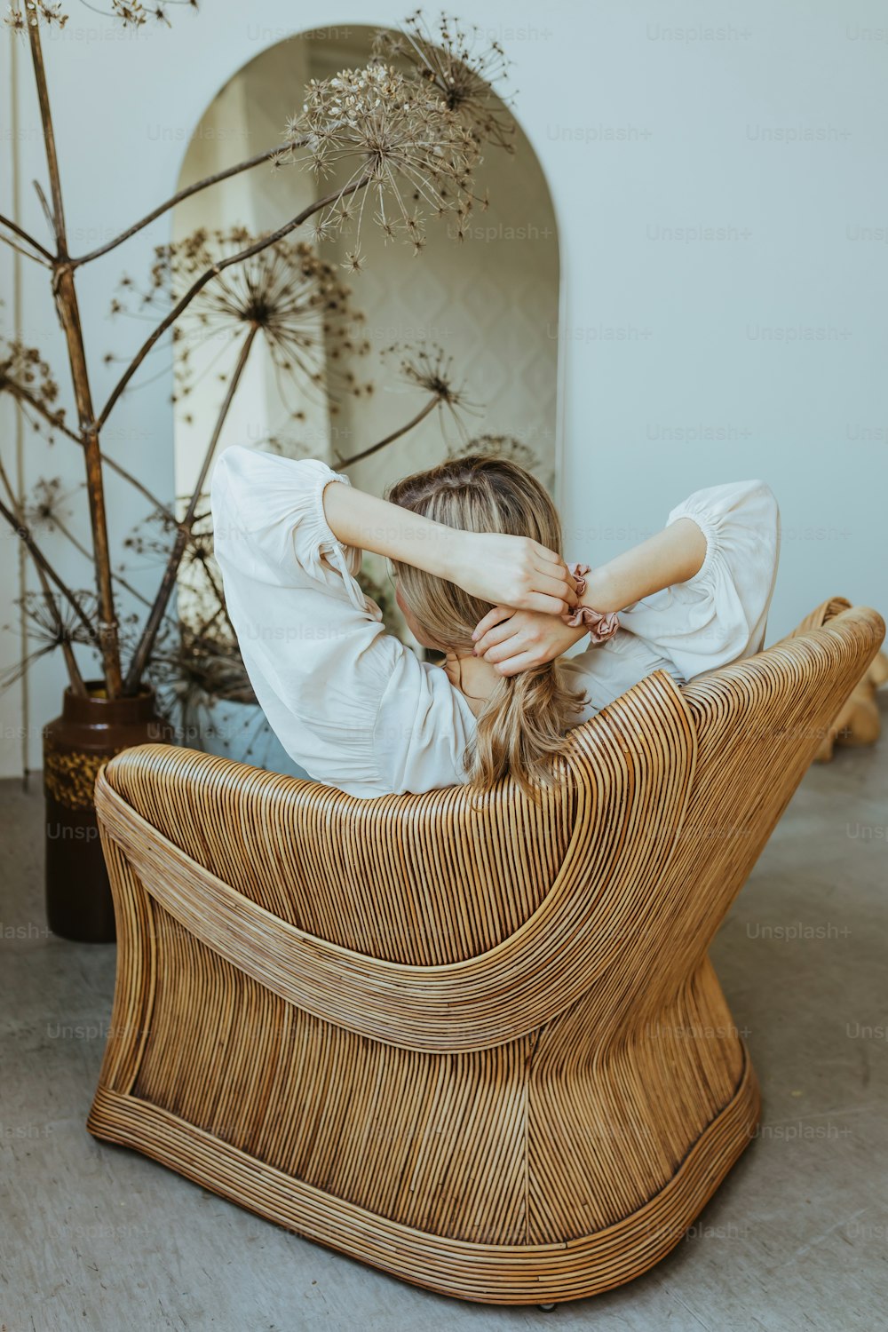 una donna seduta su una sedia con le mani sulla testa