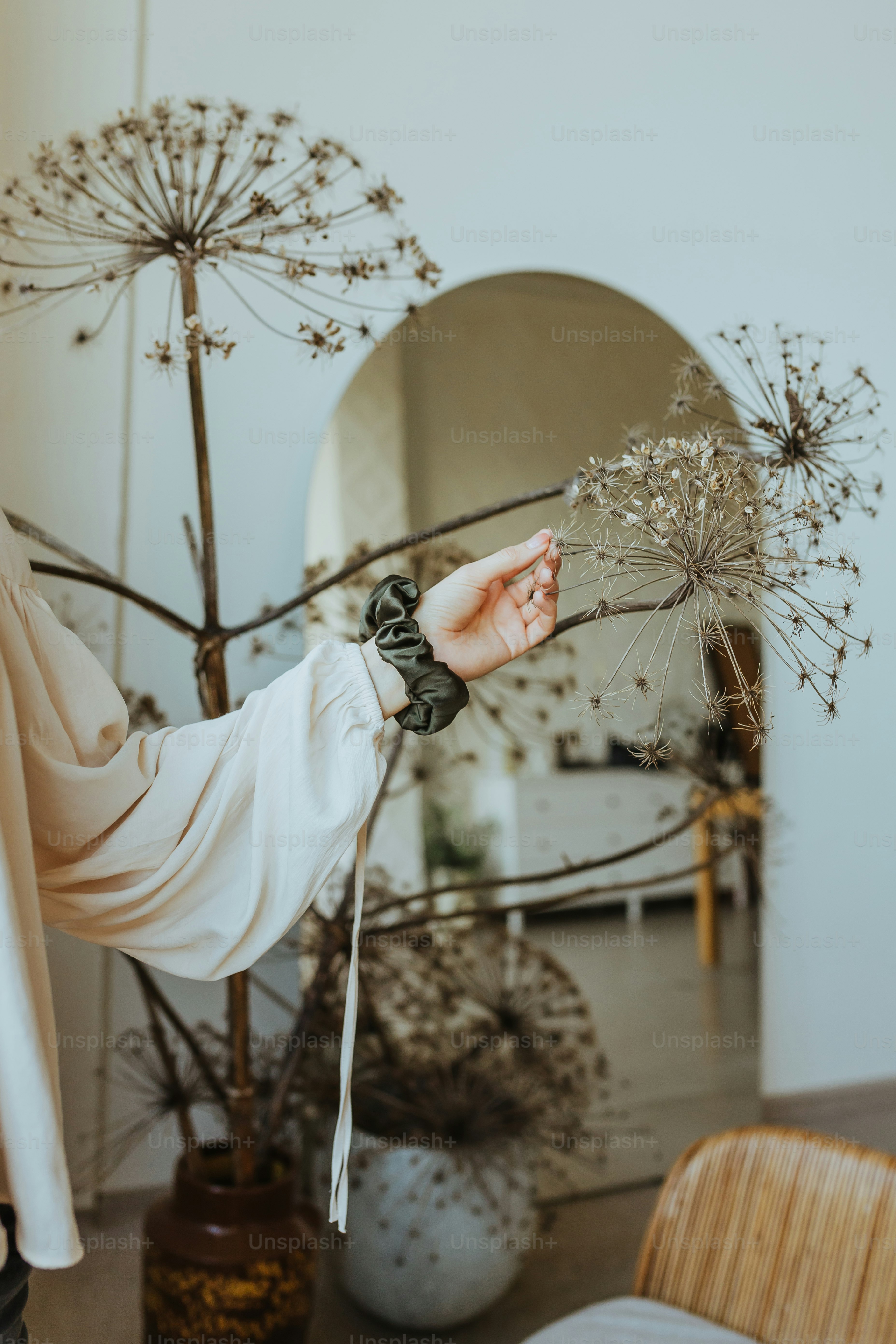 a woman holding a dandelion in her hand