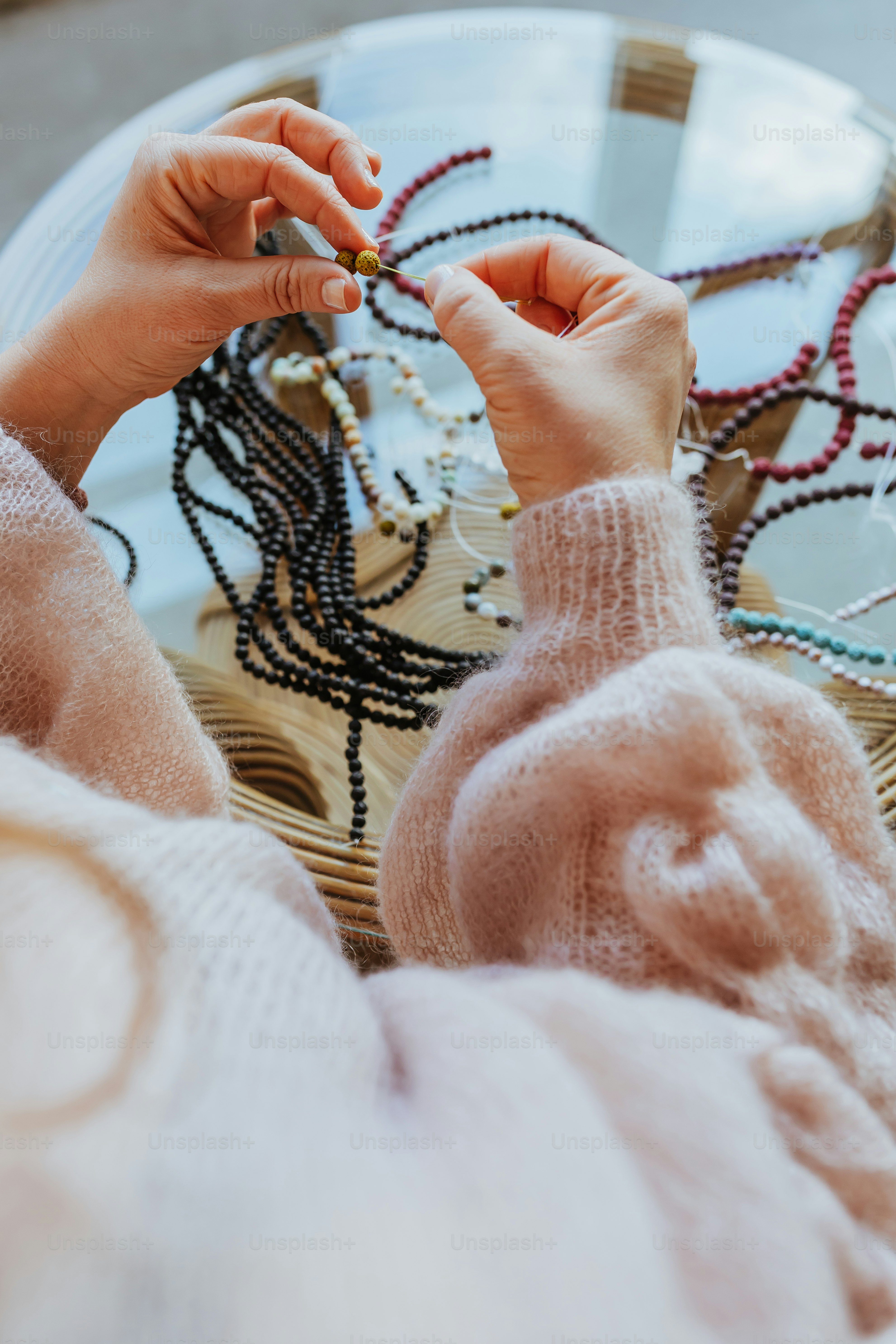a person sitting at a table with beads on it