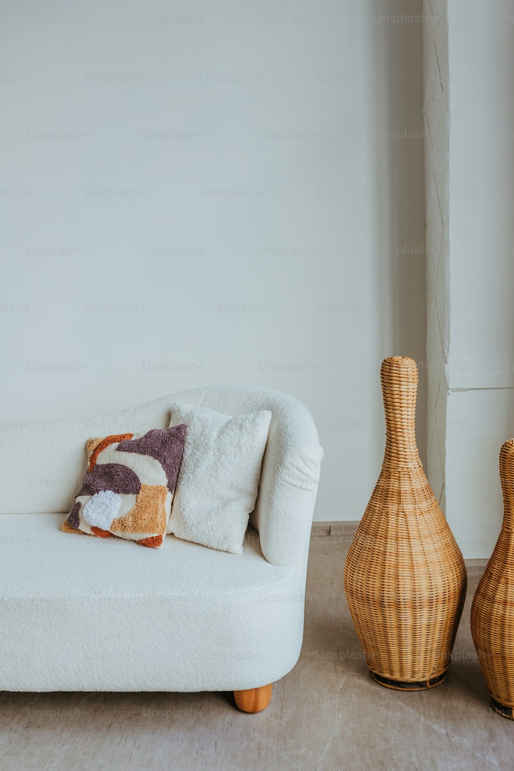 a white couch sitting next to a wooden vase