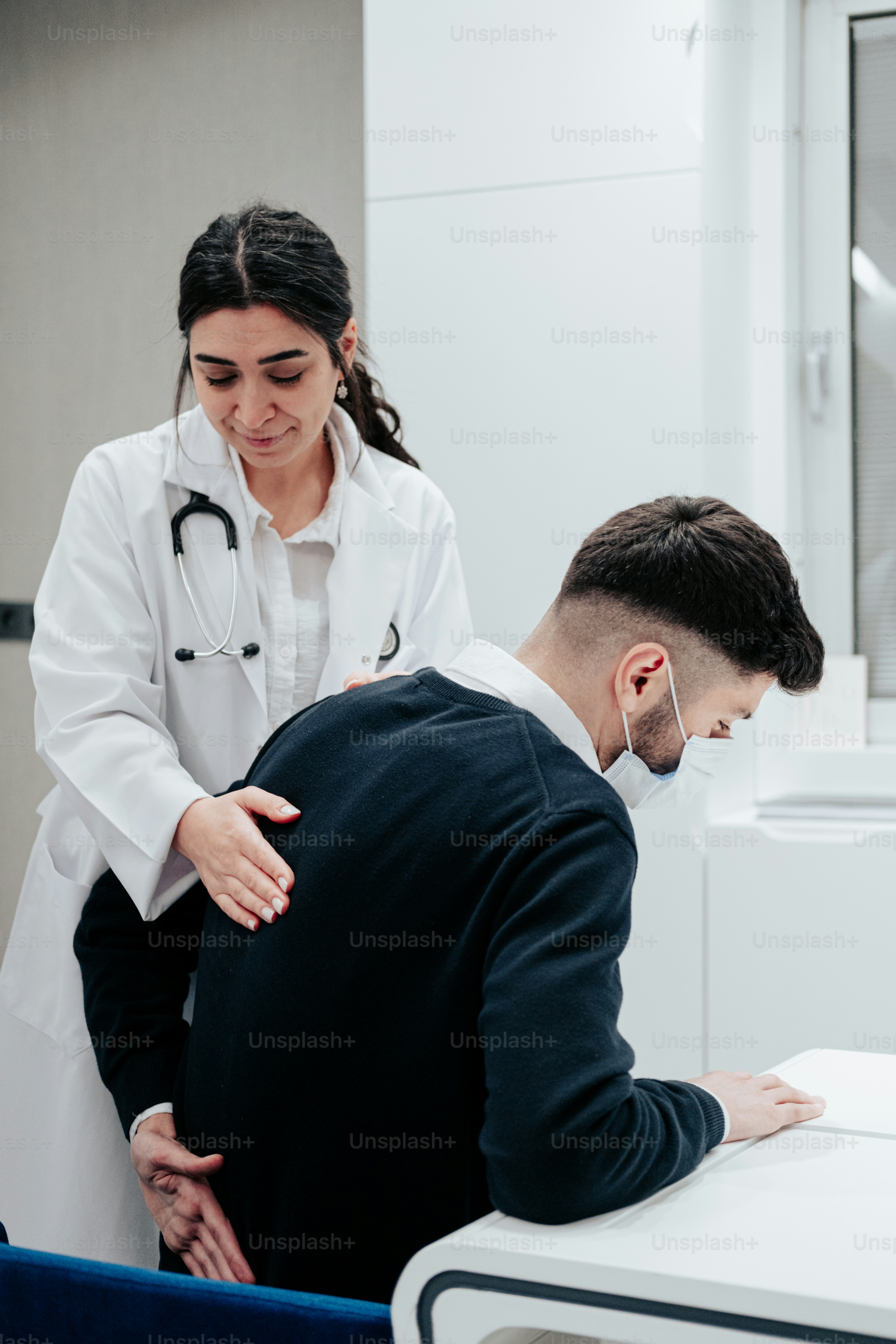 a doctor examining a patient's chest in a room