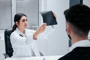 a woman in a white lab coat holding a black folder