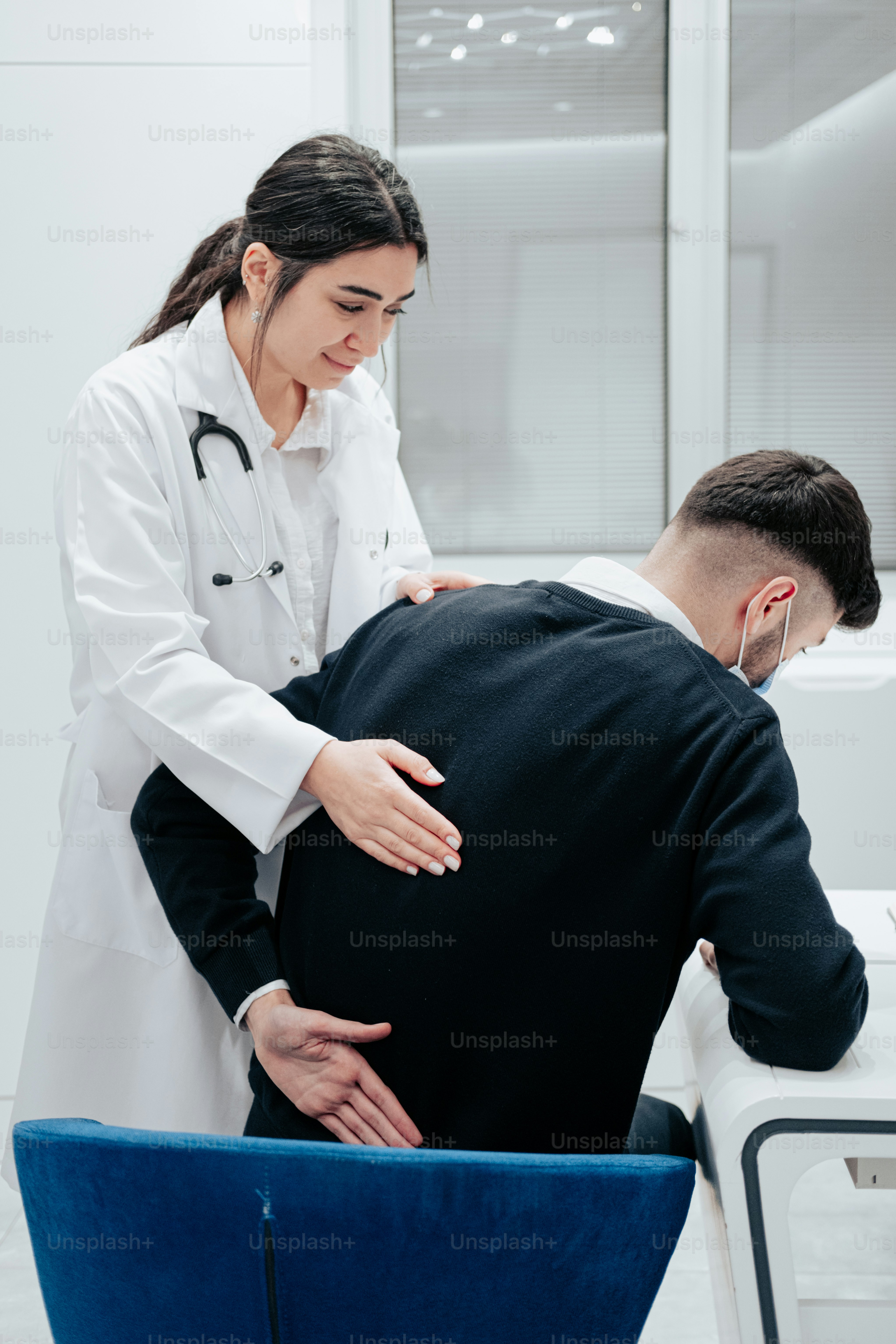 un médico que examina la espalda de un paciente