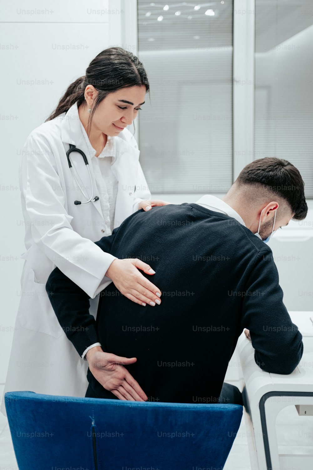 um médico examinando as costas de um paciente