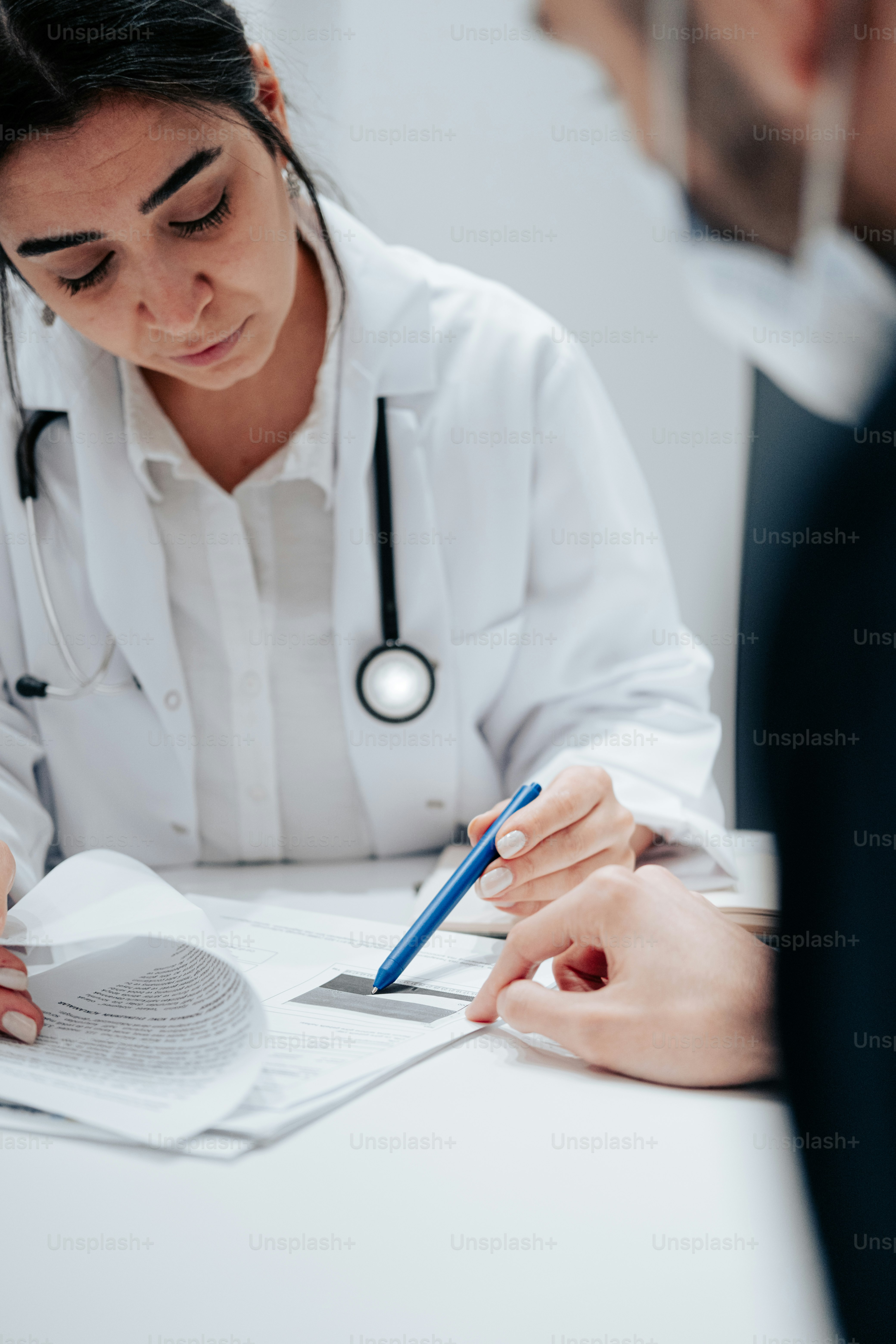 a woman in a white lab coat writing on a piece of paper