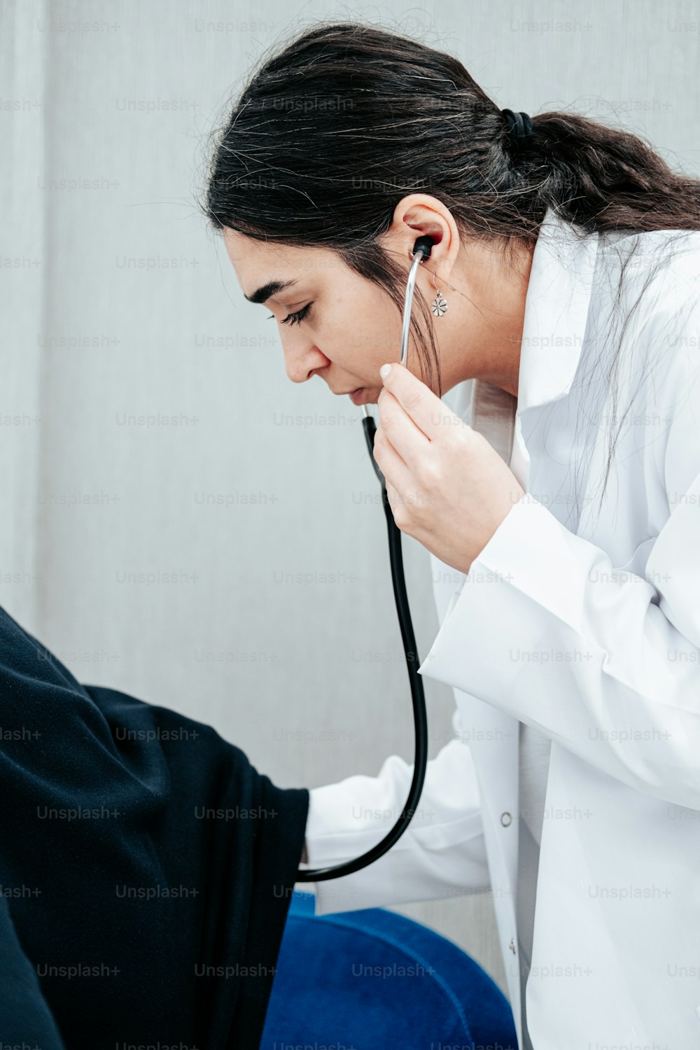 Eine Frau mit einem Stethoskop am Ohr