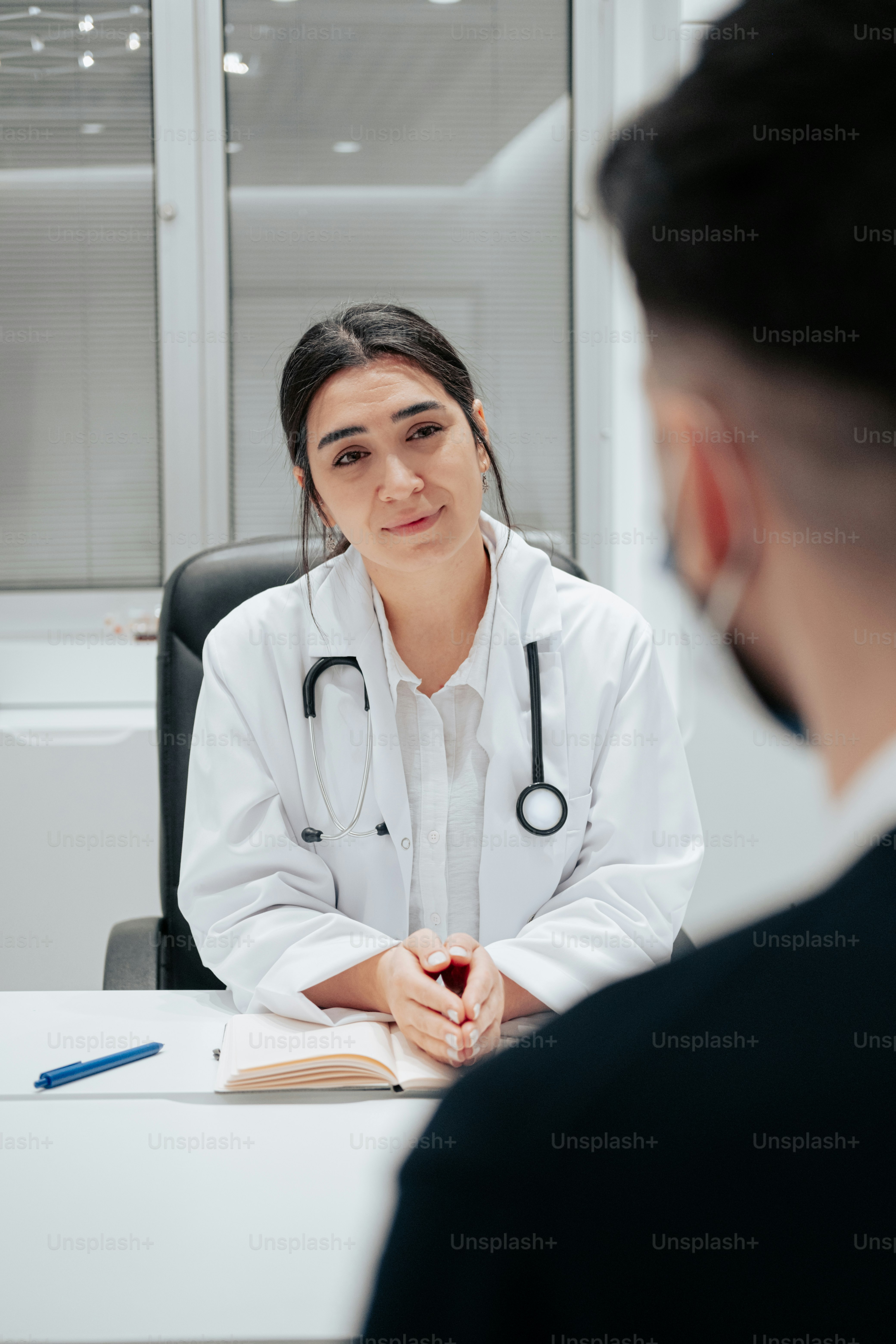 a woman sitting at a desk with a stethoscope on her shoulder