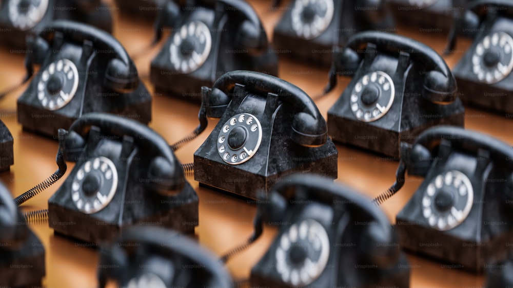 a group of old black telephones sitting on top of each other