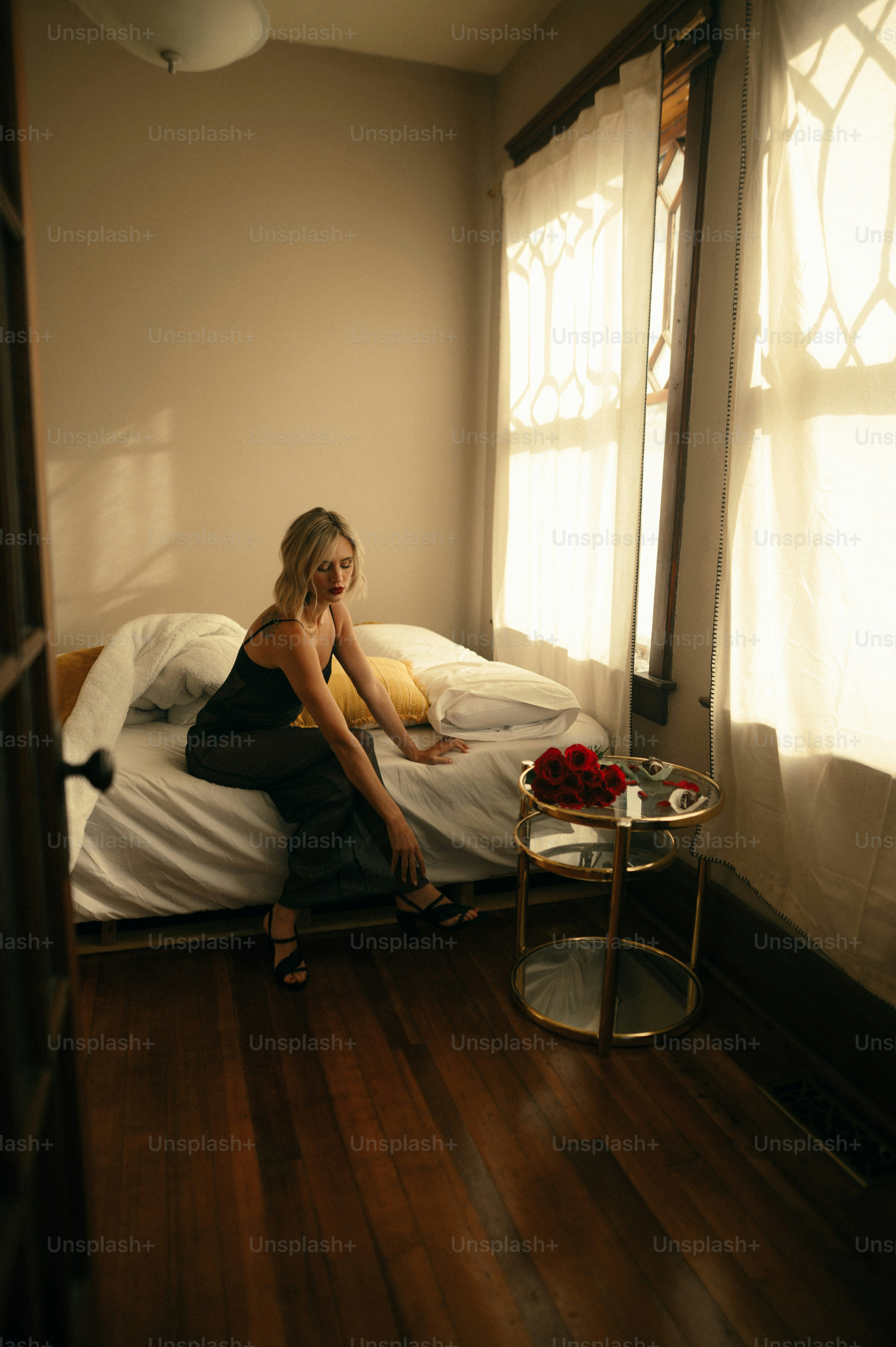 une femme assise sur un lit parlant au téléphone portable