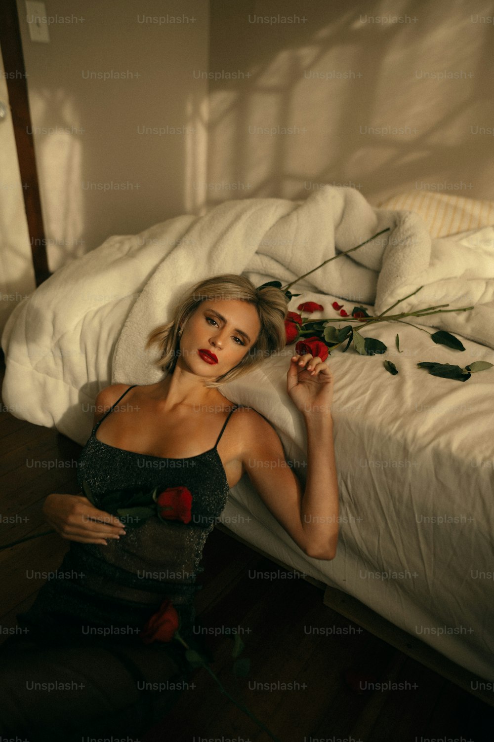 uma mulher deitada em uma cama com uma rosa na mão