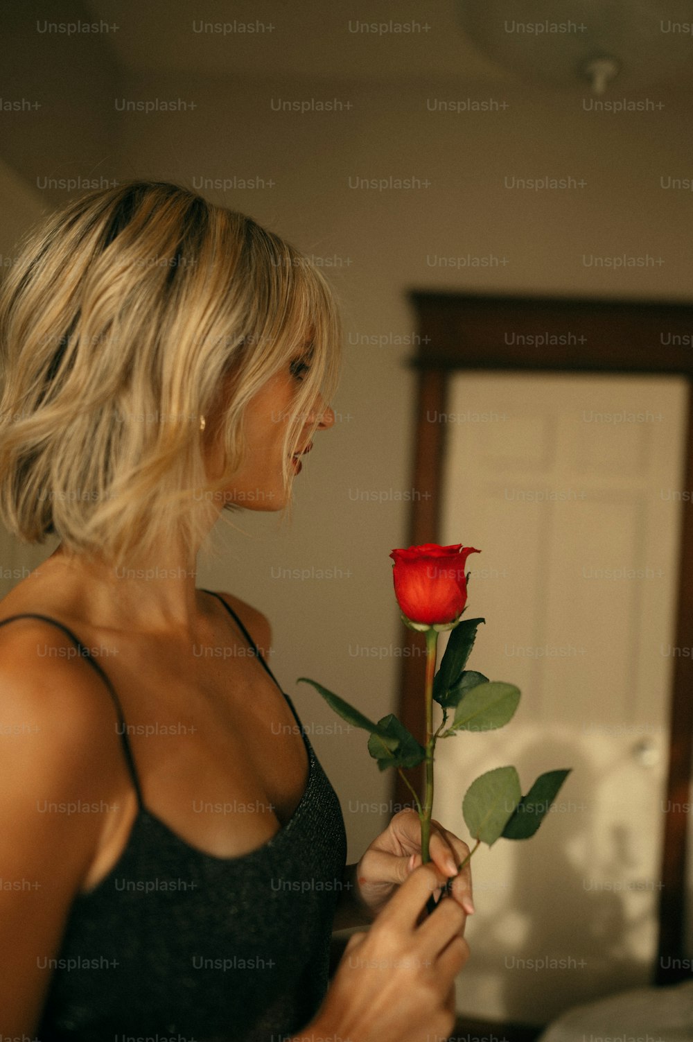 Una mujer sosteniendo una rosa roja en la mano