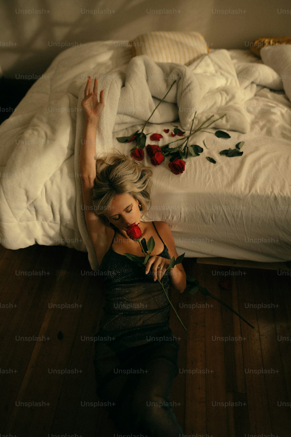 Une femme allongée sur le sol avec une rose à la main