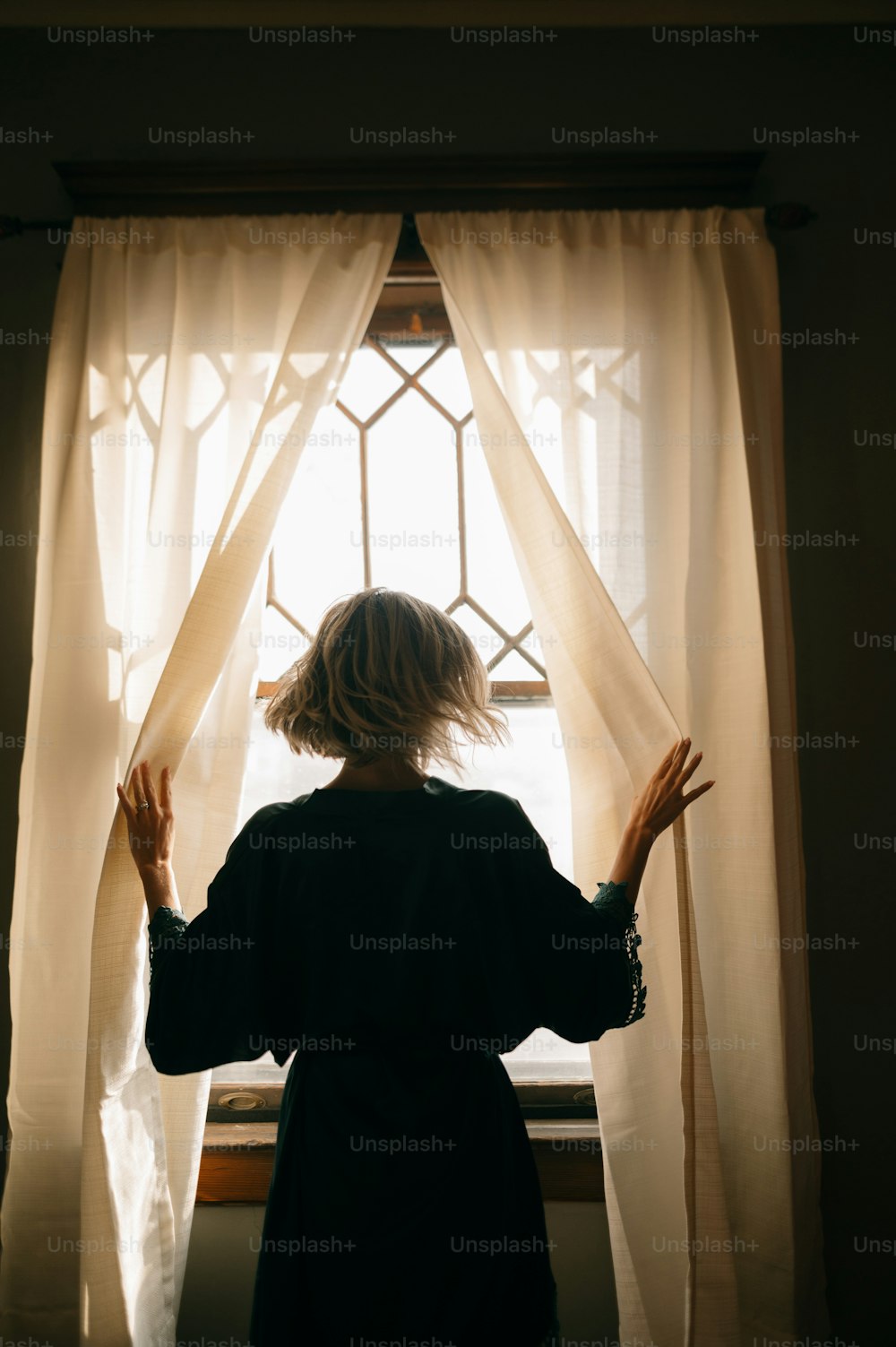 a woman standing in front of a window