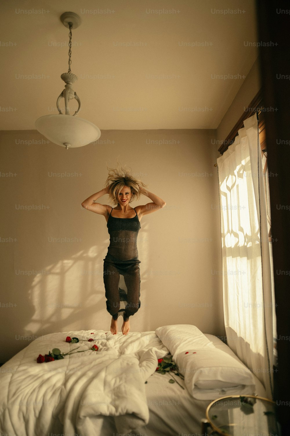 a woman jumping on a bed in a room