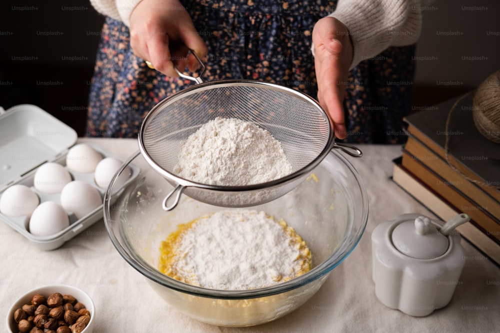 una persona che mescola gli ingredienti in una ciotola su un tavolo