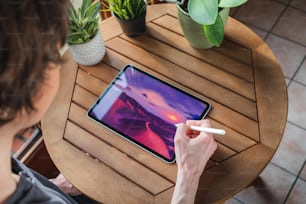 a person sitting at a table with an ipad
