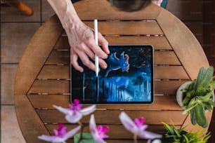 a person using a tablet on a wooden table