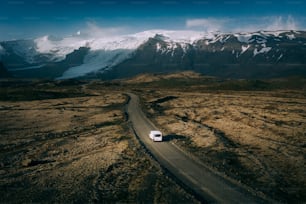 a truck driving down a dirt road in the mountains