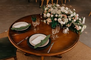 a table set with place settings and flowers