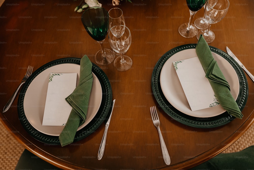 a wooden table topped with plates and silverware