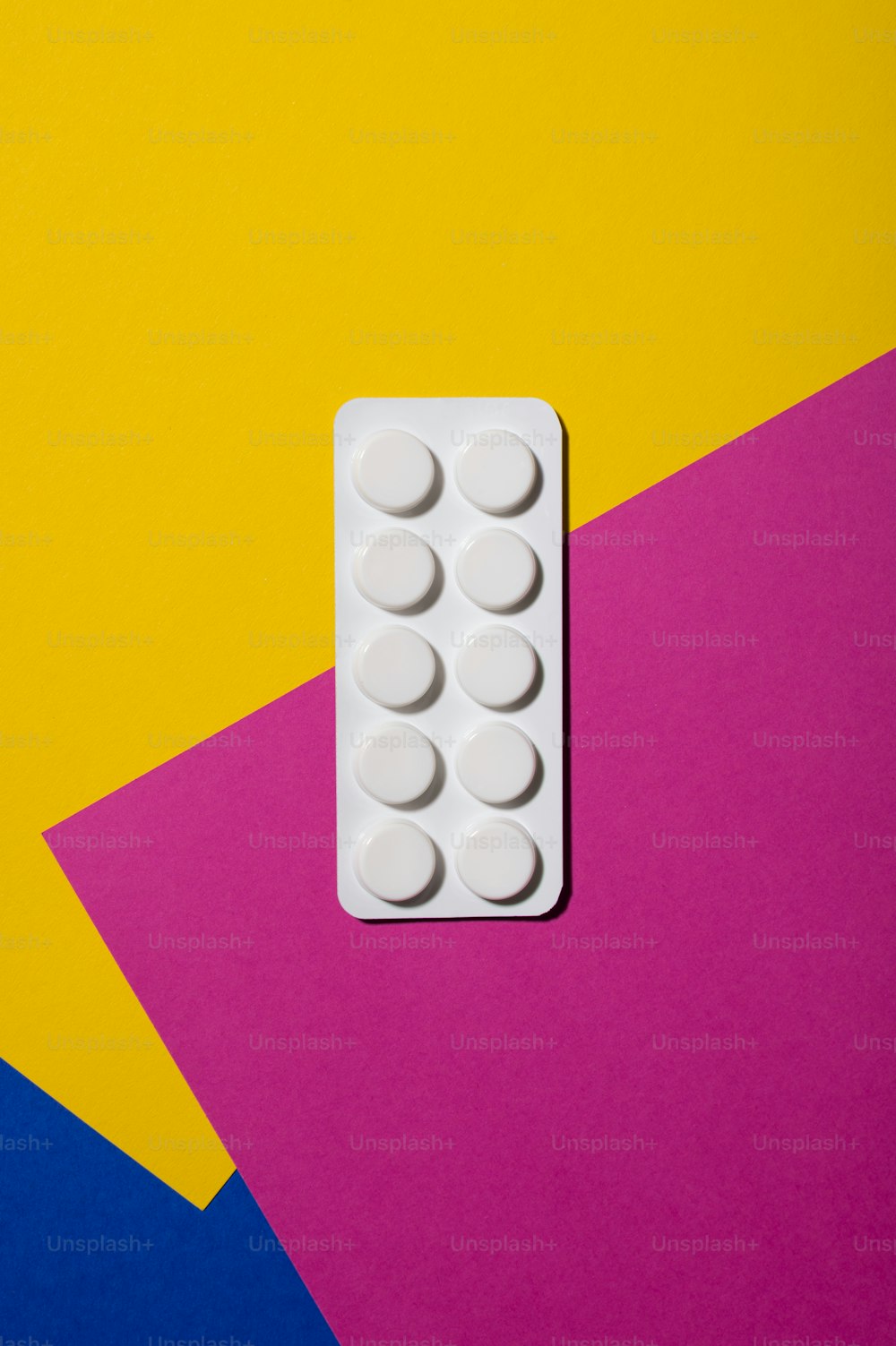 Una pillola di pillola bianca seduta sopra uno sfondo colorato