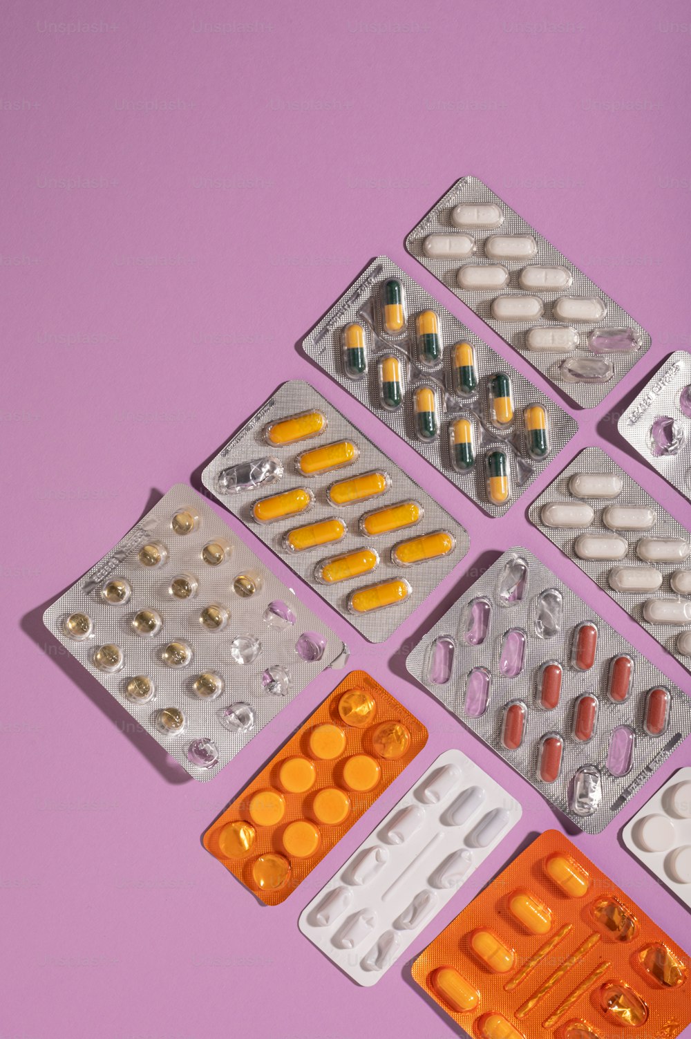 Un grupo de píldoras y tabletas sobre un fondo púrpura