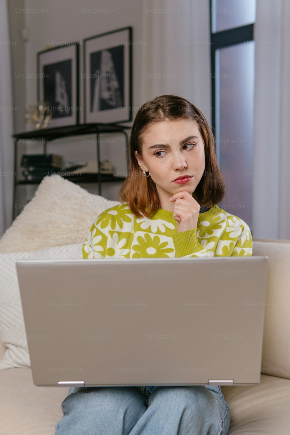 a woman sitting on a couch using a laptop computer