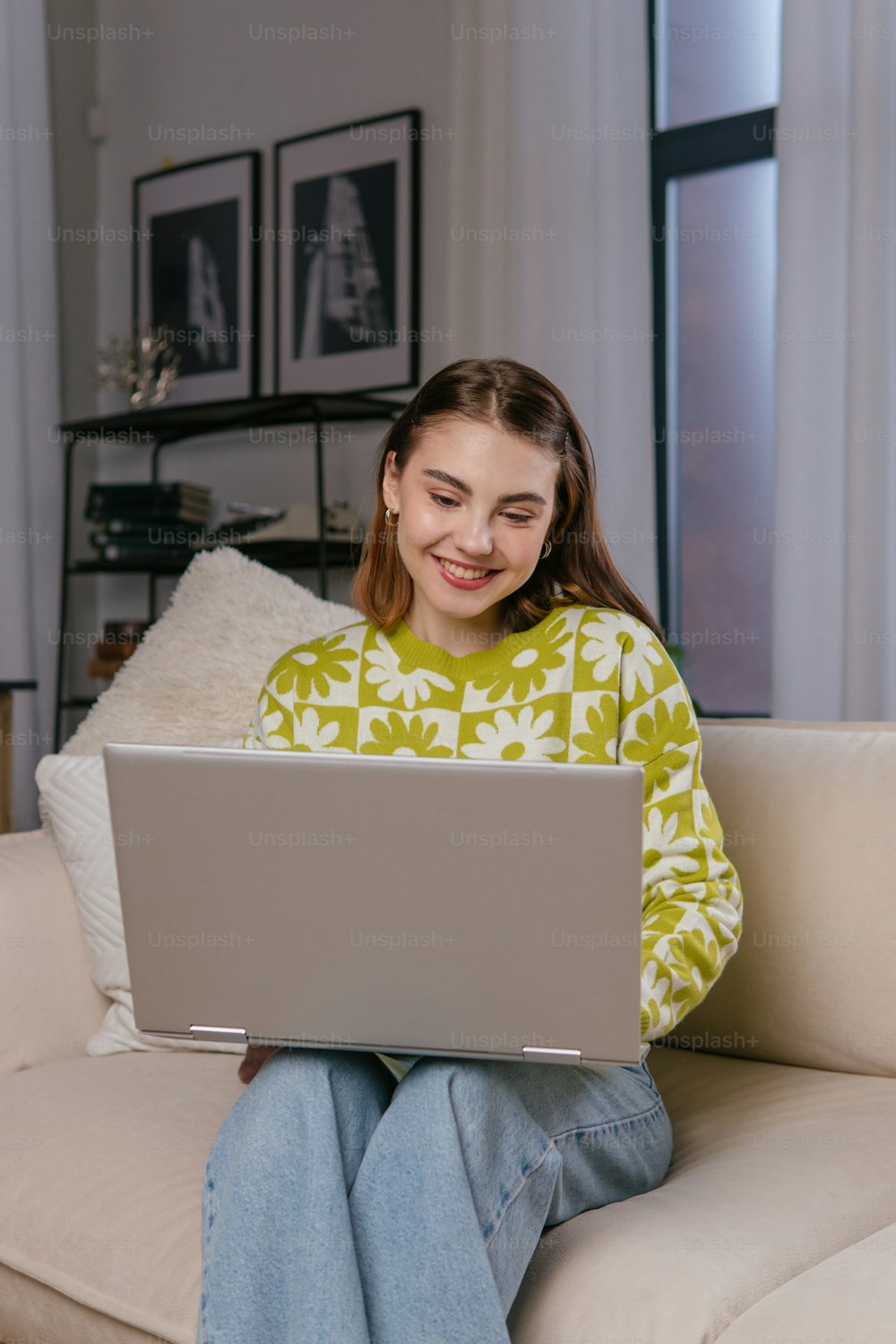 a woman sitting on a couch using a laptop computer