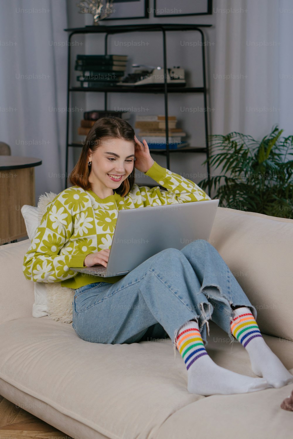 a woman sitting on a couch using a laptop computer