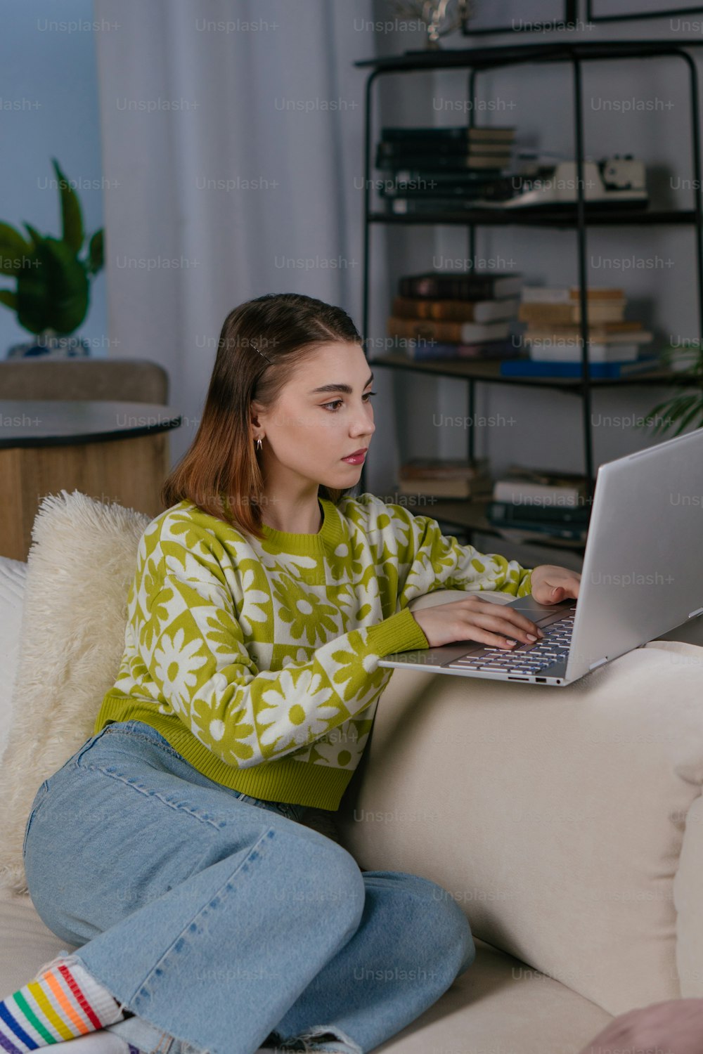 노트북 컴퓨터를 사��용하여 소파에 앉아 있는 여자