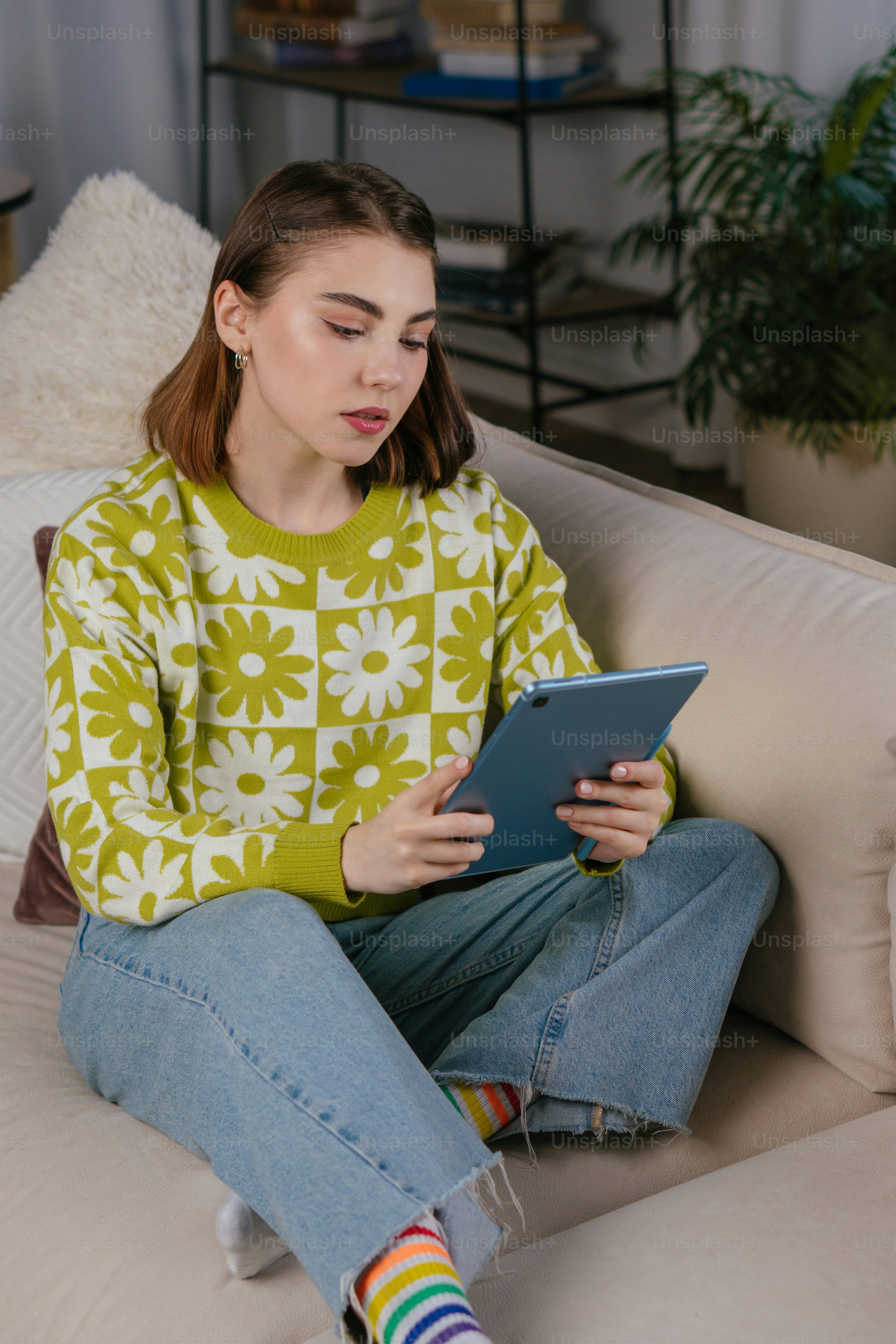 A woman sitting on a couch using a tablet photo – Office Image on Unsplash