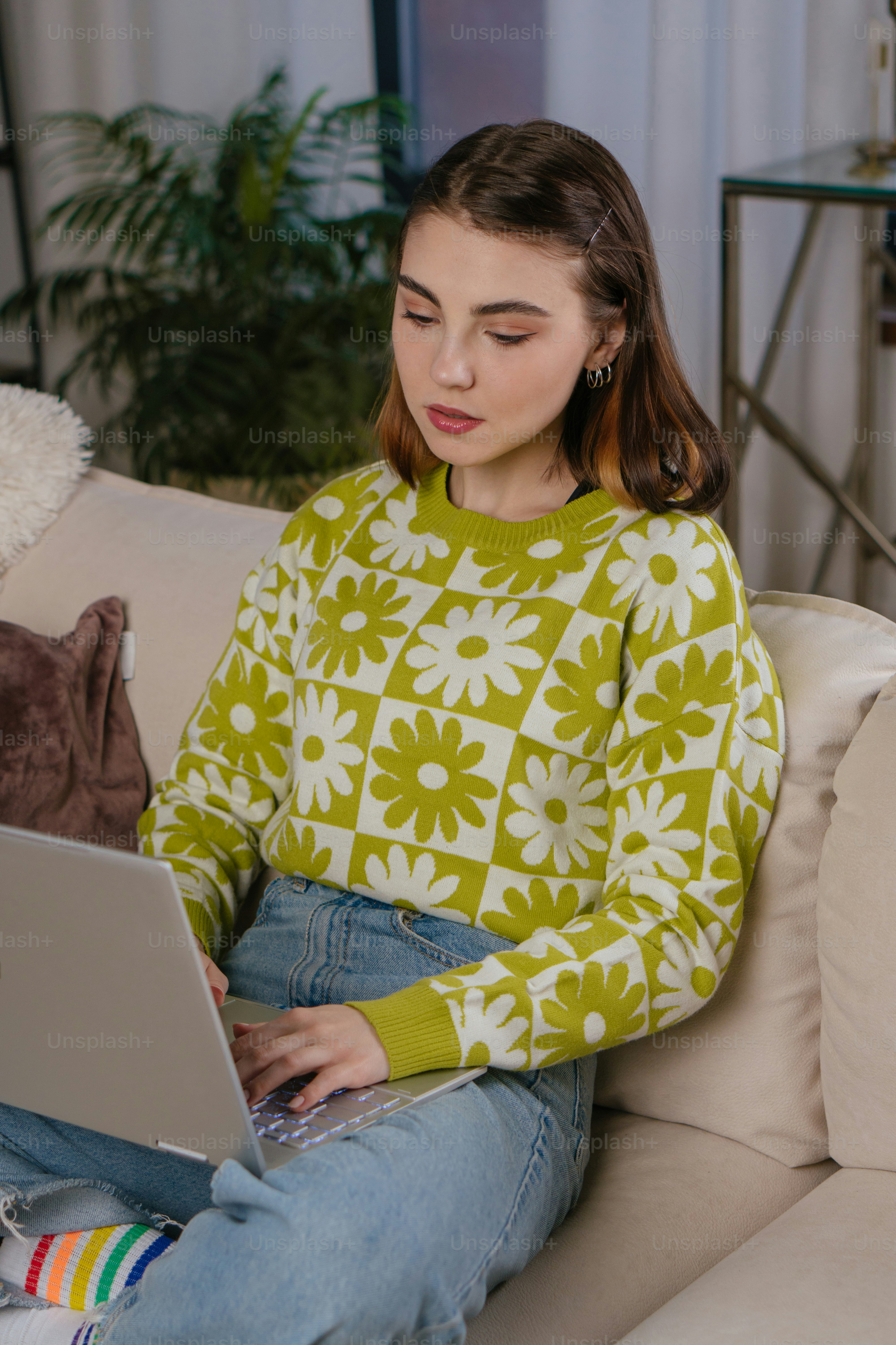 A woman sitting on a couch using a laptop computer photo – Video