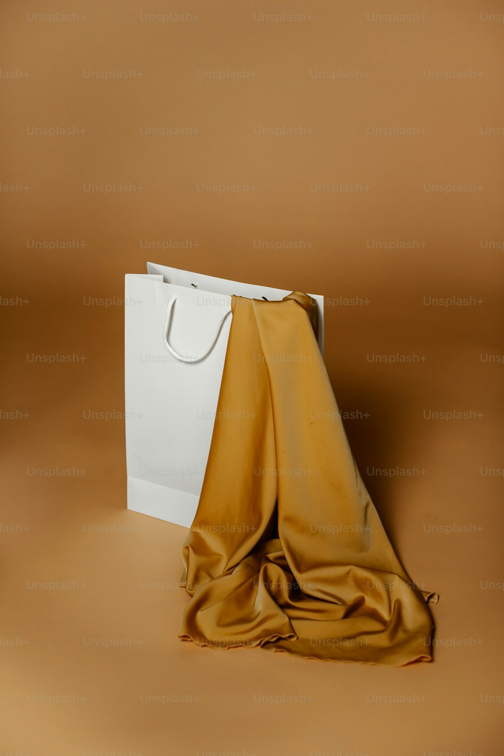 eine weiße Tasche mit einem goldenen Tuch darüber